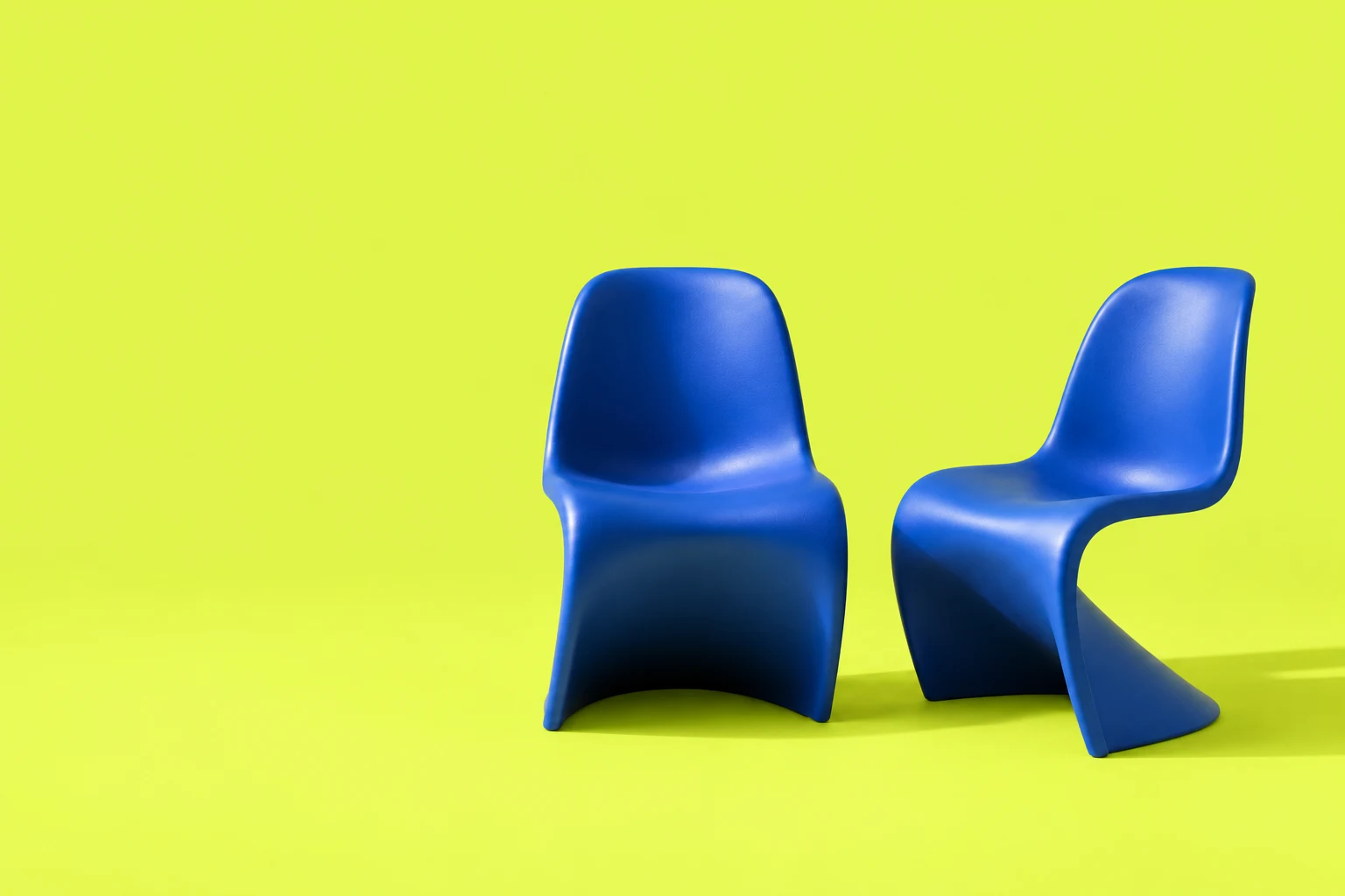 Two sculptural blue chairs, one turned toward the other